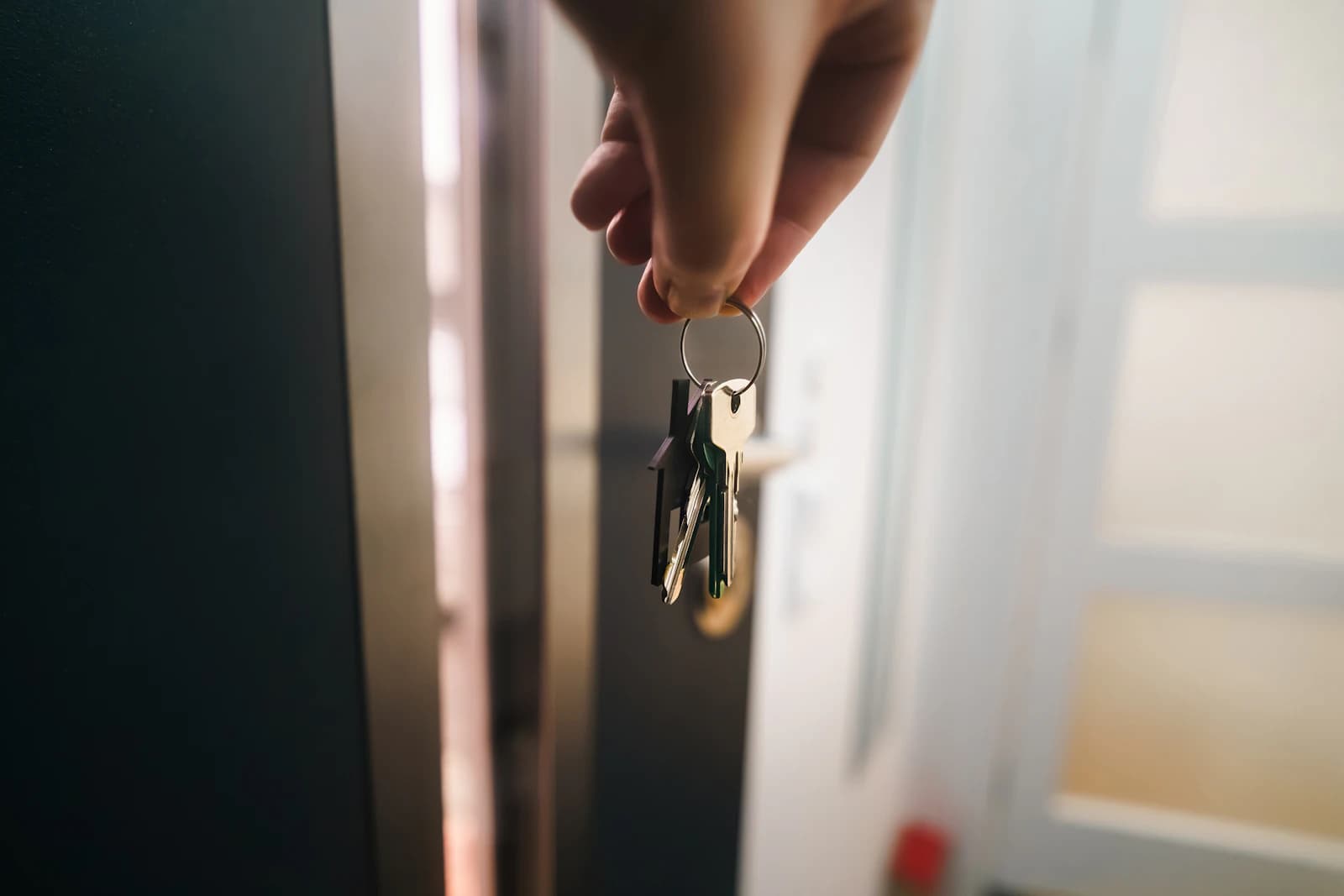 Mão segurando um chaveiro em formato de casa